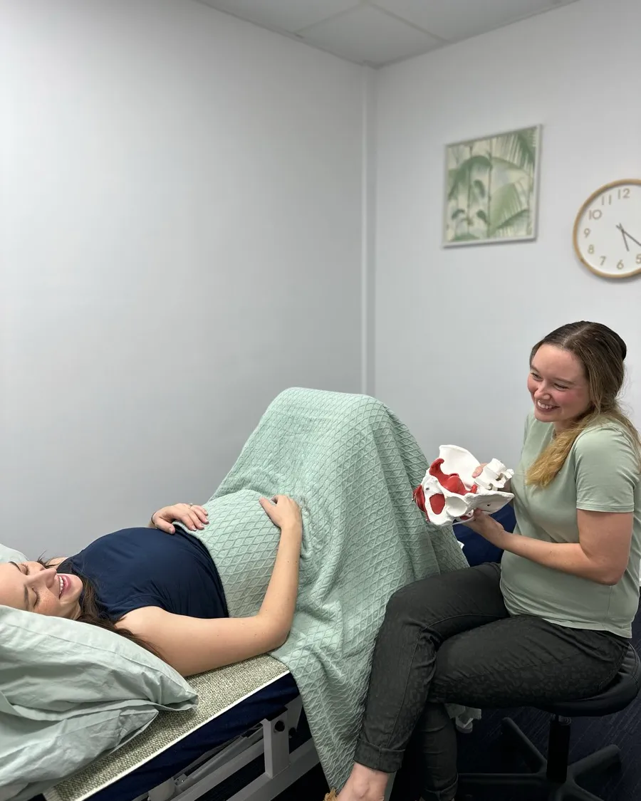 Forward Health pelvic floor physiotherapist with a pregnant patient and pelvic anatomy model